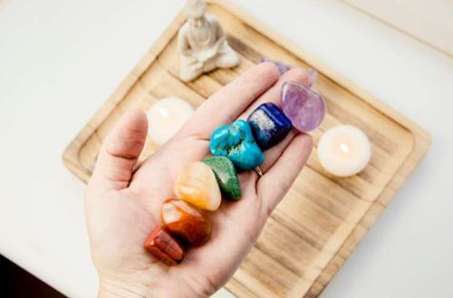 Chakra colour crystals in hand